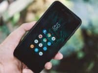 Comparação entre tela original vs genérica de celular sobre bancada de reparo